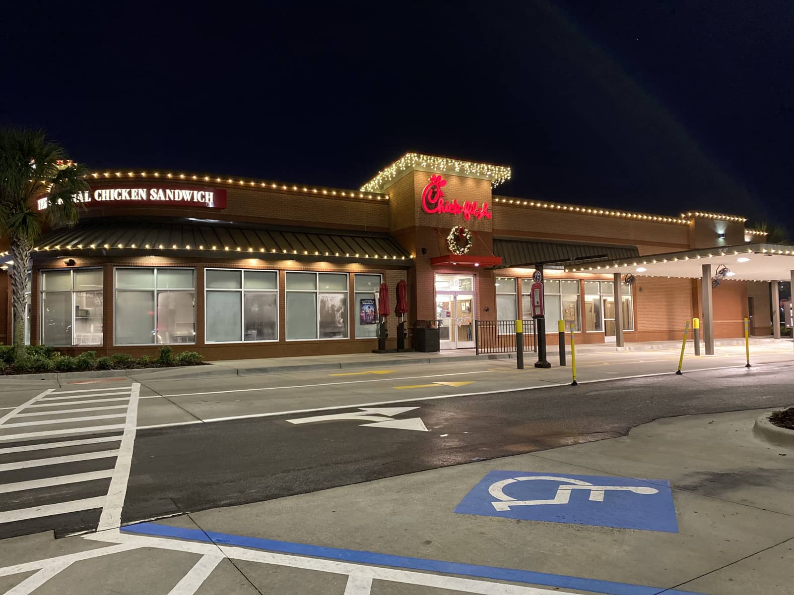 Chick-fil-A restaurant at night with string lights and brick exterior.